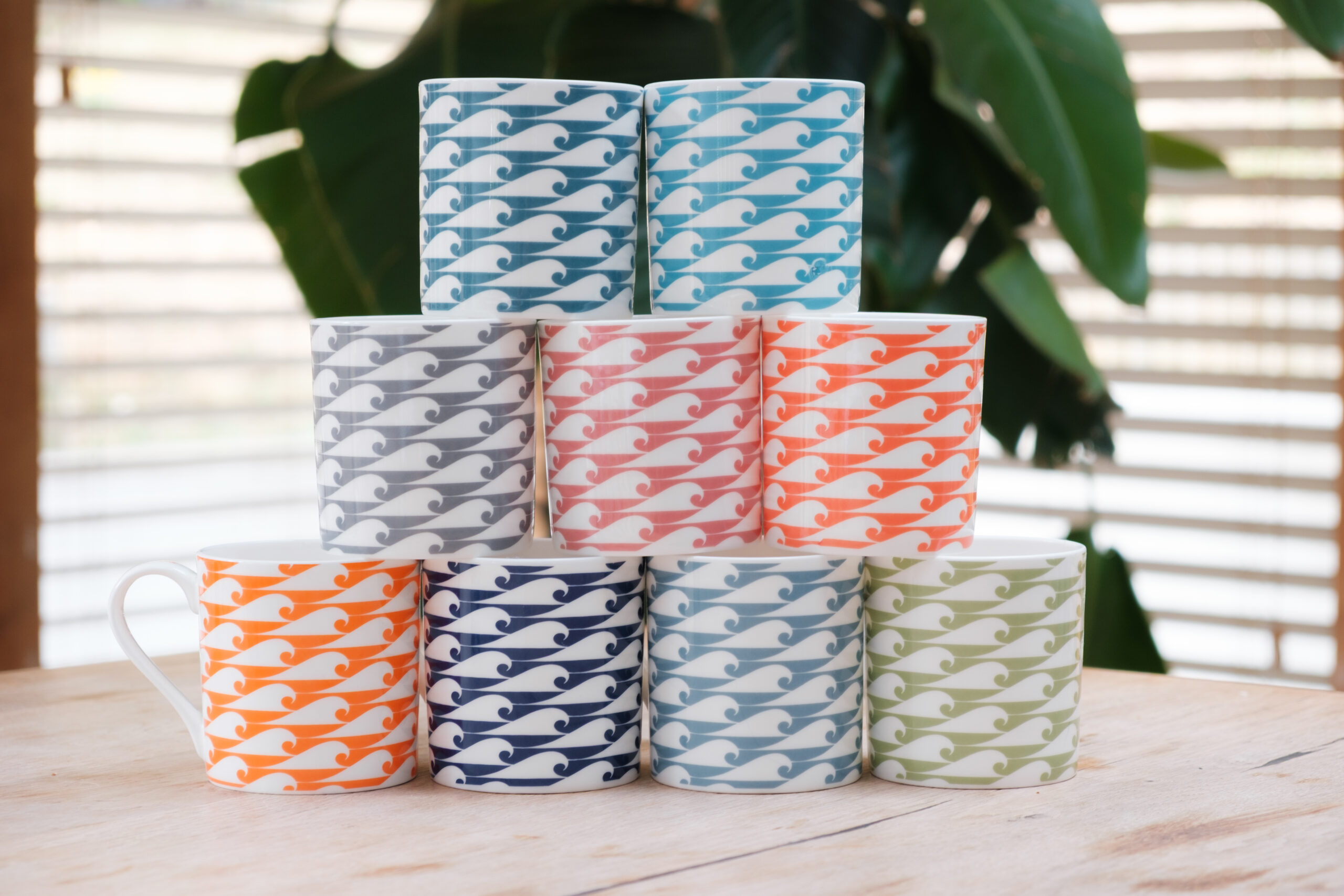 Group photo of Small Wave fine bone china mugs in assorted colours, hand finished in a small factory in Stoke-on-Trent, England.