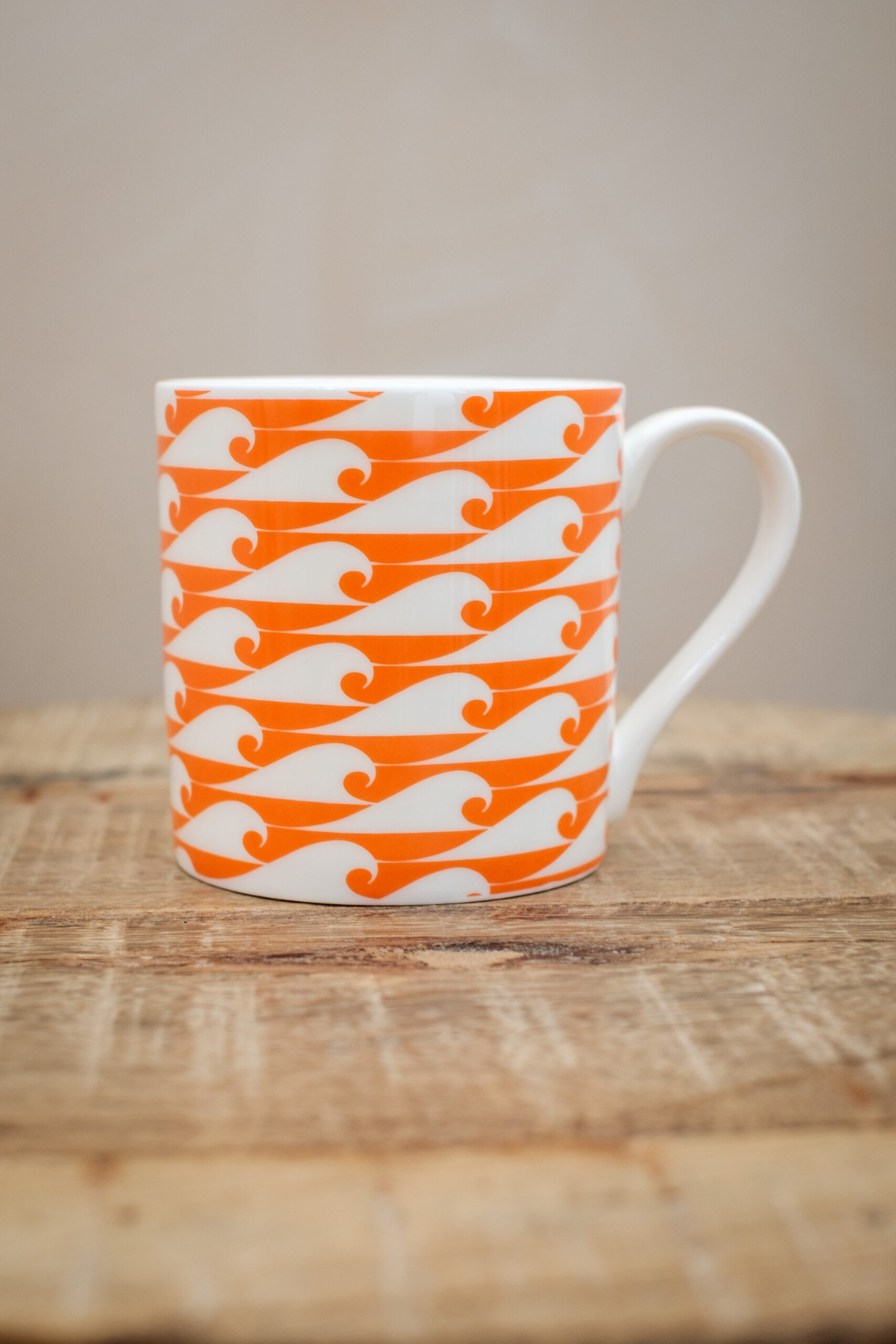 The Cornish Surfer bone china mug with campervan orange wave design, made in Cornwall.