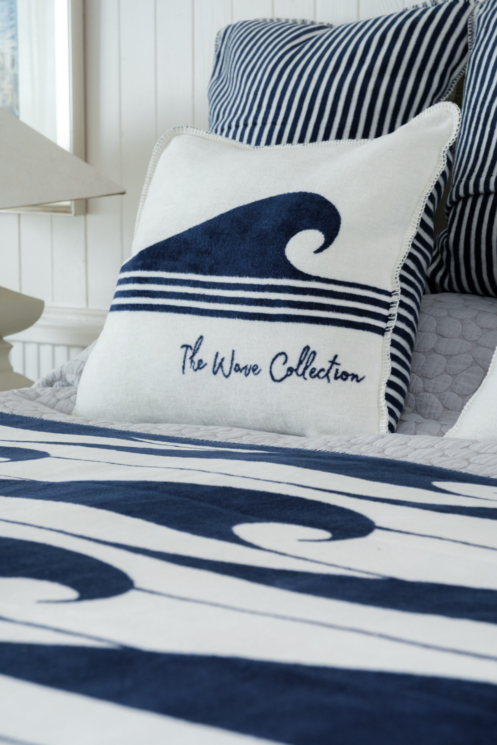 Close up of the wave collection reversible cushion showing woven texture and nautical stripes